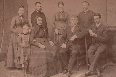 Rodinná fotografie z Karlova mládí. Ten na snímku sedí zcela vpravo, vlevo od něj babička a děda Šubertovi. V horní řadě zleva: sestra Františka, neznámý muž, Emilie a Adolf Maškovi – Karlova švagrová a bratr.